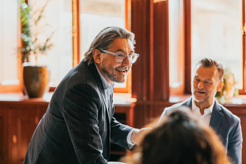 Chef pratar med kollegor under möte på kontoret