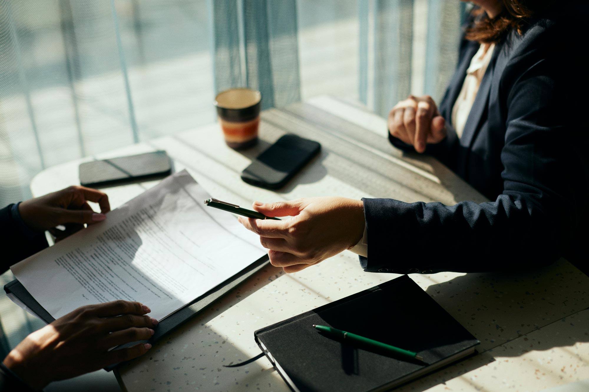 Intervjuare sträcker ut penna till kandidat under intervju