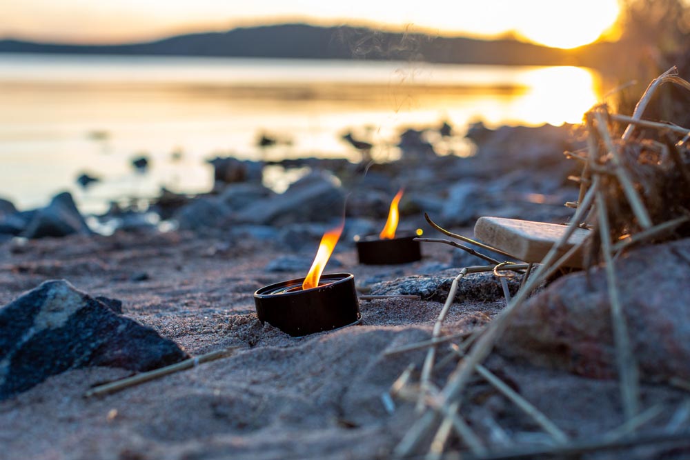 Tända marschaller på en strand med havet i bakgrunden